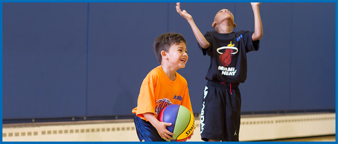 Kids smiling as they play basketball
